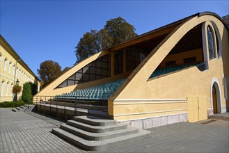 A modern yellow open-air grandstand with many steps on a sunny day, church, officers' palace,