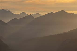 Mountain peak as silhouette in the evening light, haze, backlight, view from Nebelhorn to Allgaeu
