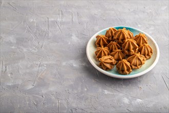 Homemade soft caramel fudge candies on blue plate on gray concrete background. side view, copy