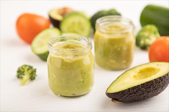 Baby puree with vegetable mix, broccoli, tomatoes, cucumber, avocado infant formula in glass jar on