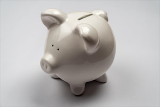 White piggy bank in front of a white background, studio shot, Germany, Europe