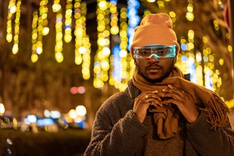 African man wearing smart goggles in the city at night during Christmas eve
