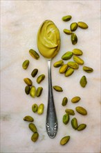 Pistachio cream in spoon and pistachios, pistachio vera