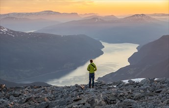 View of mountains and fjord Faleidfjorden, at sunset, mountaineer at the summit of Skala, Loen,