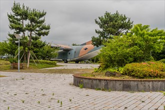 Fairchild C-123K Provider military aircraft on display at museum under cloudy sky in Jeju, South