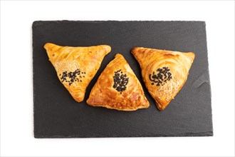 Homemade asian pastry samosa on black slate board isolated on white background. top view, flat lay,