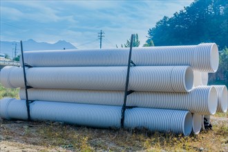 Stack of industrial sewer pipes in rural wilderness park
