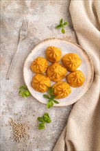 Fried manti dumplings with pepper, basil on gray concrete background and linen textile. Top view,