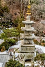 Four story stone carved pagoda on plinth of three elephants at Buddhist temple in South Korea