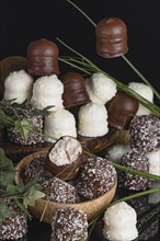 Chocolate kisses arranged decoratively on a wooden board and in a coconut half