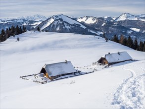 Winter atmosphere, snow-covered landscape, snow-covered alpine peaks, alpine huts on the