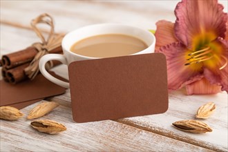 Brown paper business card mockup with purple day-lily flower and cup of coffee on white wooden