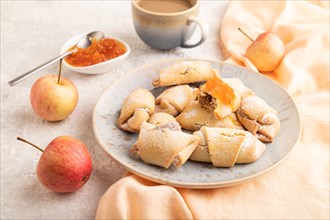 Homemade sweet cookie with apple jam and cup of coffee on gray concrete background and orange linen