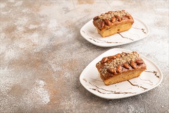 Caramel and almond cake on brown concrete background. side view, copy space