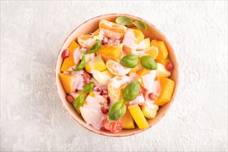 Vegetarian fruit salad of yogurt pumpkin, tangerine, pomegranate, grapefruit, basil microgreen