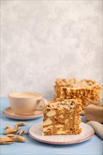 Traditional lithuanian cake shakotis with cup of coffee on blue wooden background and linen textile