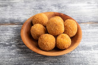 Meat balls on a wooden plate on a gray wooden background. Side view, close up