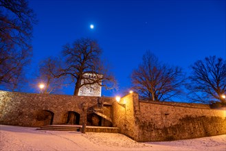 Garden of the Moellenvogtei with historic city wall and defence defence tower under the moon in the