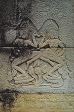 Bas-relief of Apsaras, celestial dancers from Hindu mythology, carved in stone in Khmer style.