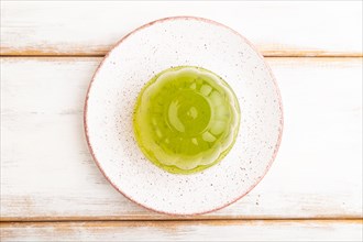 Mint green jelly on white wooden background. top view, flat lay, close up