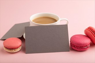 Gray paper business card mockup with red and purple macaroons and cup of coffee on pink pastel