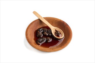 Pine cone jam in wooden bowl isolated on white background. Side view, close up
