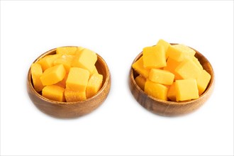 Dried and candied mango cubes in wooden bowls isolated on white background. Side view, close up,