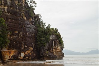 Cliff in Bako national park, overcast, cloudy day, sky and sea. Vacation, travel, tropics concept,