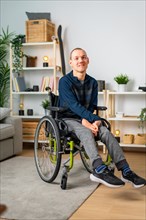Vertical portrait of a happy disabled man in wheelchair at home