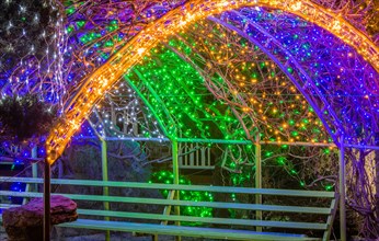 Colorful Christmas lights on metal awning over park bench in South Korea