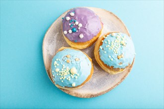Purple and blue glazed donut on blue pastel background. top view, flat lay. Breakfast, morning,