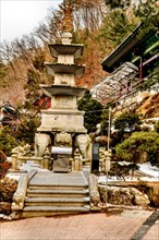 Four story stone carved pagoda on plinth of three elephants at Buddhist temple in South Korea
