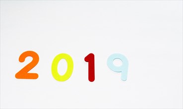The numbers 2019 made of felt of different colors photographed on white background