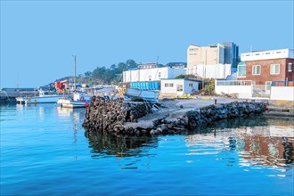 Landscape of small fishing port on calm morning under blue sky in Jeju, South Korea, Asia