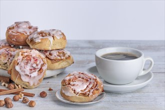 Homemade cinnamon buns next to cup with coffee, copy space, white background