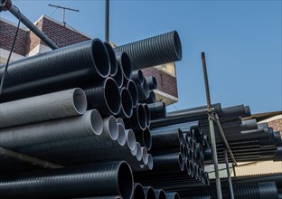 Large diameter pvc pipes stored on metal scaffolding outside