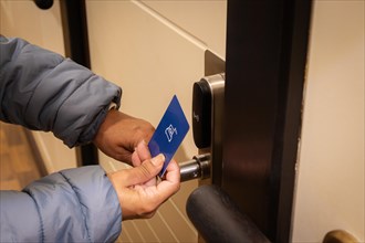 Woman hand using electronic smart key card to unlock door in hotel or house. Digital lock, door