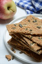 Crispbread with seeds on a plate and apple