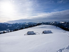 Winter atmosphere, snow-covered landscape, snow-covered alpine peaks, alpine huts on the