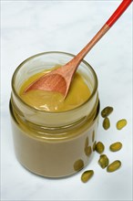 Pistachio cream in jar with spoon, pistachios