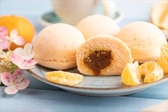 Japanese rice sweet buns mochi filled with tangerine jam and cup of coffee on a blue wooden
