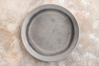 Empty gray ceramic plate on gray concrete background. Top view, copy space, flat lay