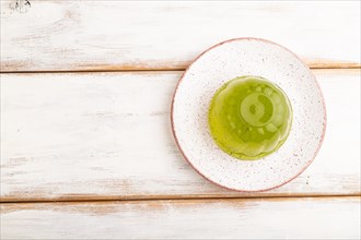 Mint green jelly on white wooden background. top view, flat lay, copy space