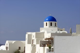 White houses in typical Cycladic architecture, above a Greek domed church, Oia, Ia, Santorini,