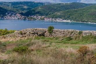 Remains of castle wall ruins with Bosphorus Strait and coastal village in background in Istanbul,