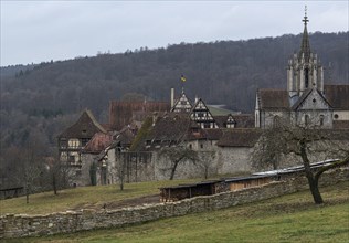 View of a medieval monastery with church tower and half-timbered houses on a cloudy day