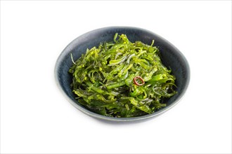 Chuka seaweed salad in blue ceramic bowl isolated on white background. Side view