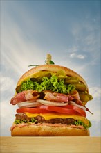 Low angle view of beef burger with bacon, cheese and vegetables