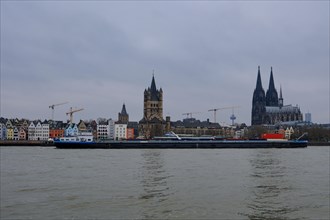 View over the Rhine with cathedral and cargo ship, Cologne, Germany, Europe