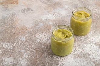 Baby puree with vegetable mix, broccoli, tomatoes, cucumber, avocado infant formula in glass jar on